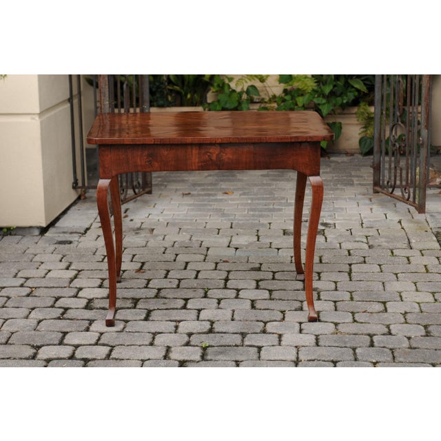 An Italian walnut quarter-veneered side table from the late 18th century, with single drawer and cabriole legs. Born in...
