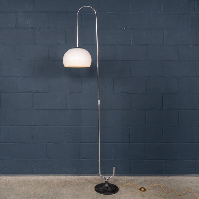 A minimalist italian floor lamp dating to the 1970s, defined by its elegant, sculptural silhouette. The design features a...
