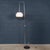 A minimalist italian floor lamp dating to the 1970s, defined by its elegant, sculptural silhouette. The design features a...