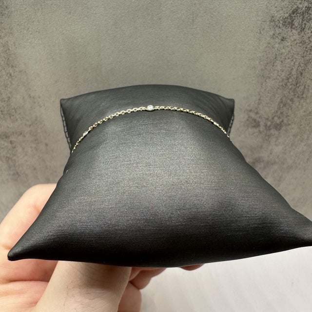 This delicate diamond station bracelet in 14kt yellow gold features 0.15 carats total weight of natural GH SI2–I1 round...