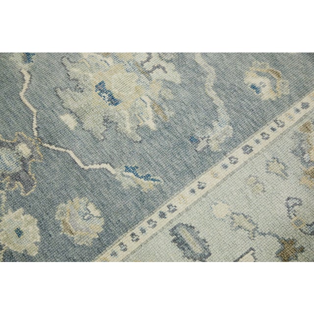 This modern Turkish Oushak rug is a stunning piece of art that has been handwoven using traditional techniques by skilled...