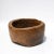 A substantial hand-hewn wooden bowl carved from a single burl section, retaining its irregular form and textured interior....