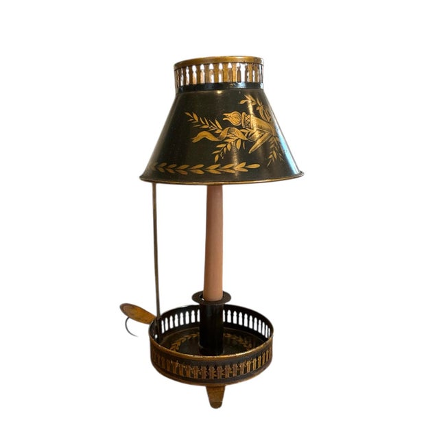 A stunning, tole Bouillotte candle lamp. Features a black metal candle lamp with hand applied gilt details featuring horns...