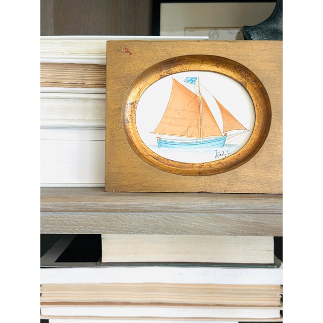 A charming hand-painted sailboat painting, full of soft coastal color and old-world character. The artwork features a...