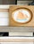 A charming hand-painted sailboat painting, full of soft coastal color and old-world character. The artwork features a...