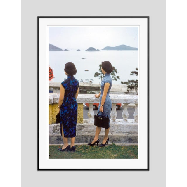 Balcony Cheongsams by Toni Frissell Two elegantly dressed women in classic Hong Kong-style cheongsams overlooking the...