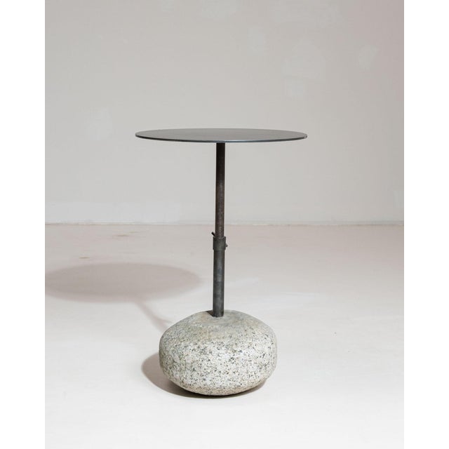 Round stone-base side table in Deep Charcoal Grey. The deep charcoal grey surface highlights rounded natural stone base,...
