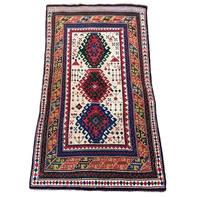 A beautiful little antique Kazak rug, woven in the Caucasus mountains of modern day Azerbaijan circa 1920. It features a 3...