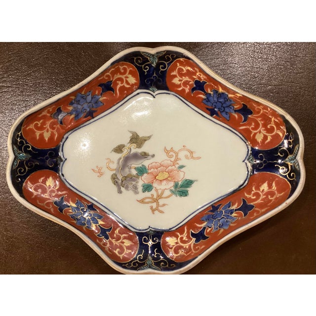 The border of iron red, cobalt blue, and gold surrounds a traditional center featuring a lion-dog and peony motif. The...