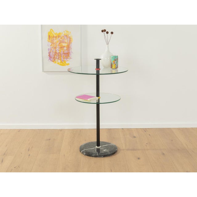 Postmodern side table from the 1980s. High-quality marble base with black metal frame and two glass plates. Quality...