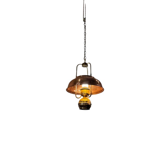 Vintage copper hanging light featuring a warm, aged copper finish, curved dome shade, and unique exposed bulb design. The...