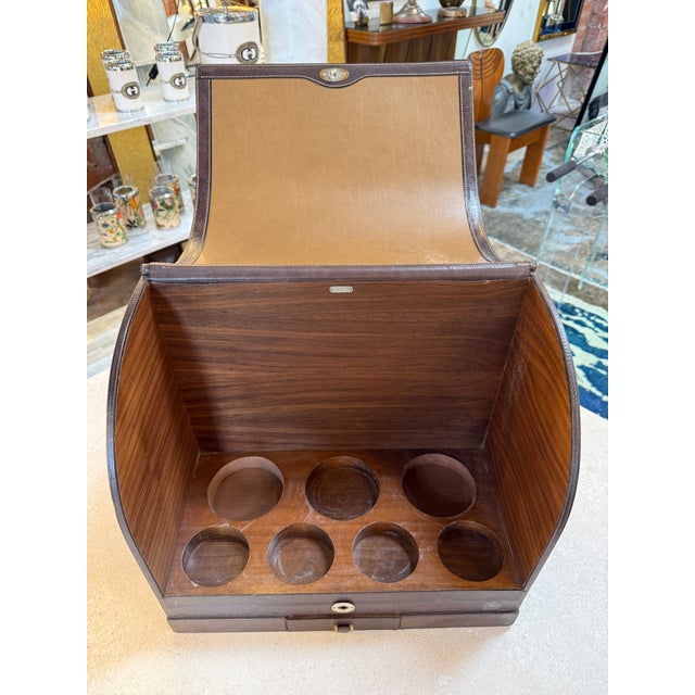 Elegant vintage bar box by Gucci, crafted in Italy and combining refined walnut veneer with rich brown leather trim and...