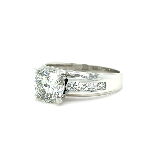 A classic and elegant diamond engagement ring crafted in 900 platinum, featuring a striking round brilliant cut centre...