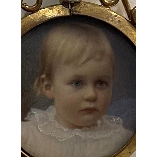 1901 portrait miniature of a child framed in a metal frame, probably intended to be a pendant worn on a chain around the...