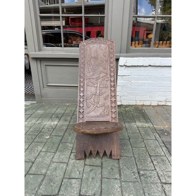 Hand-carved wooden chair, reminiscent of "star-gazing" chairs traditionally made by the Senufo people of the Ivory Coast....
