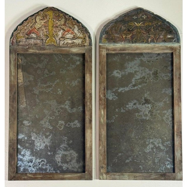 An extraordinary and rare pair of 19th century arched mirrors, retaining their original hand-painted crest panels and...