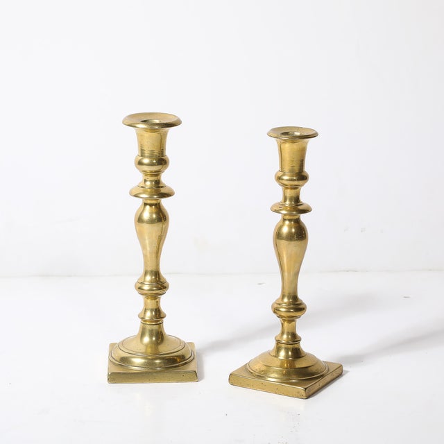 This elegant near pair of Neoclassical candleholders, crafted in the United States, circa 1900. These showcase the...