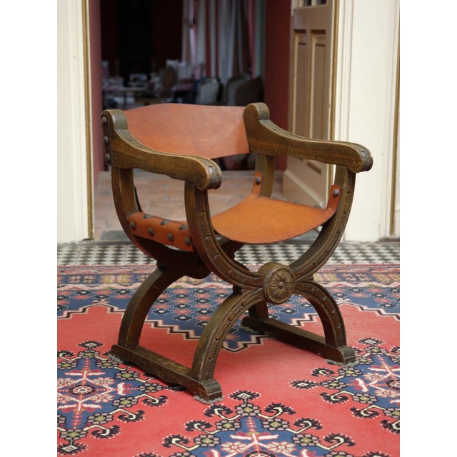 Antique Dagobert armchair made of solid oak with leather seat and backrest. The design is based on a historical medieval...