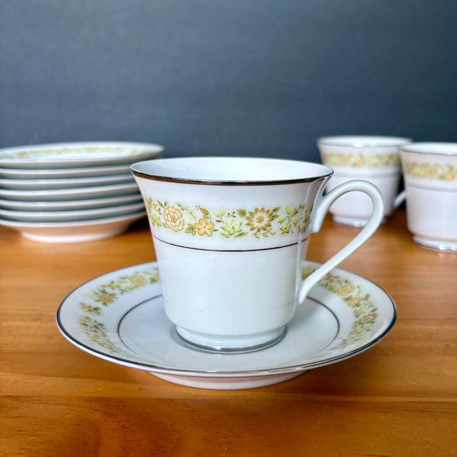 Delicate vintage Towne House “Spring 3094” teacup and saucer set, featuring a soft band of yellow florals accented with...