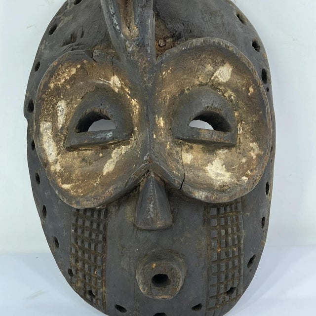 One notable feature of the Bembe Helmet Mask that offers insight into its age and method of creation is the presence of...