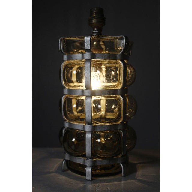 Venetian-style lamp made of blown glass in a metal cage, with dual lighting featuring two bayonet-base bulbs. The lamp is...