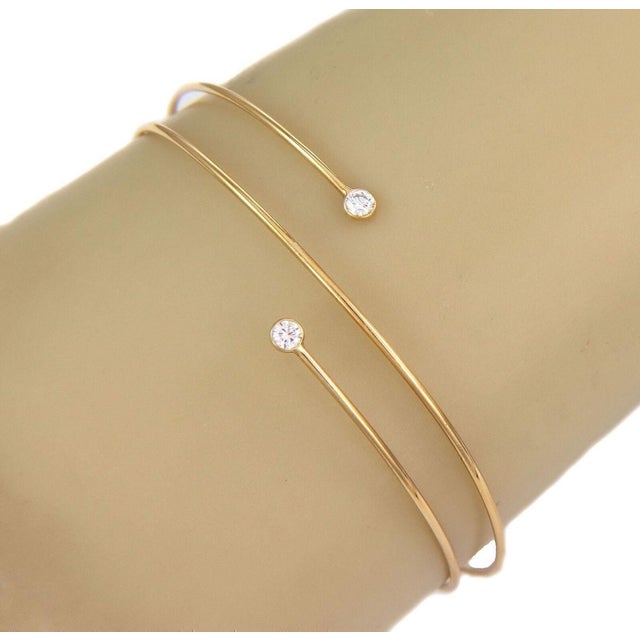 Elevate your jewelry collection with the iconic Tiffany & Co. Peretti Diamond Hoop Bracelet. Crafted from luxurious 18k...