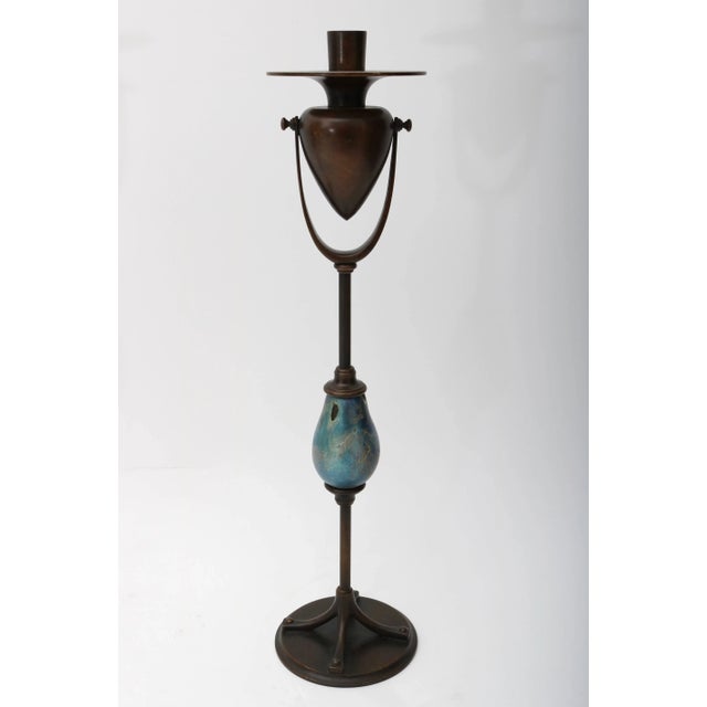 This handsome pair of candle holders are fabricated in cast bronze and molten favrile glass in the form a stylized...