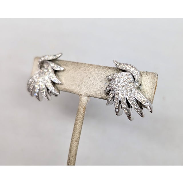 1980s rhodium plated "swish" round clear rhinestone clip earrings. Marked "PANETTA" on the clips and earring backs....