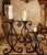 Striking set of three oversized iron floor candelabras featuring dramatic hand-forged-style scrollwork and substantial,...