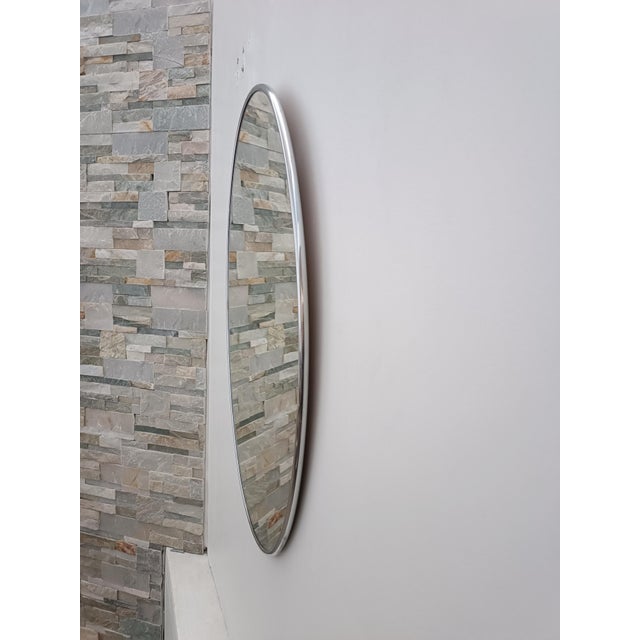 Beautiful vintage mirror. Italy, 1970s. A polished, chrome-plated cylindrical metal frame surrounds and supports this...