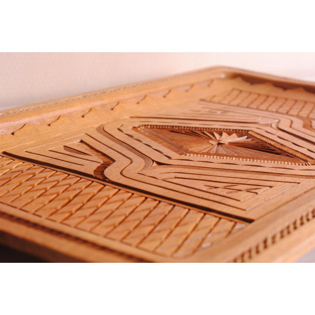 This carved wooden serving tray embodies traditional craftsmanship with a touch of rustic elegance. Its detailed design...