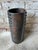 Tall vintage ceramic vase, featuring a dark bronze finish and distinct raised studs running vertically down the body of...