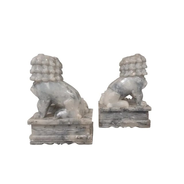 Vintage pair of of soapstone foo dogs . White and gray in color.