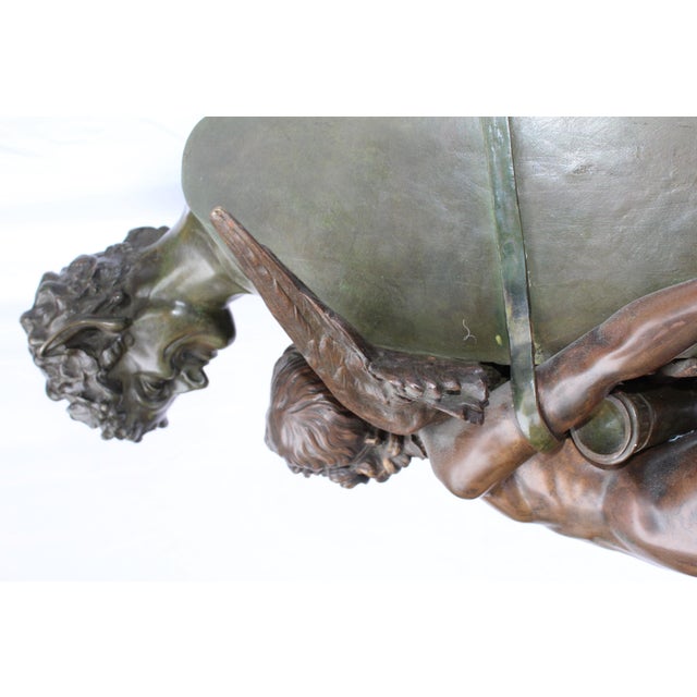 A large sculpture of angel in bondage held by the Devil image. Great patinas and mounted on red marble with brass bottom...