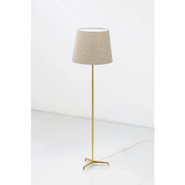 This is a Swedish floor lamp produced sometime around the 1950s. It is made from polished brass with a tripod base. The...