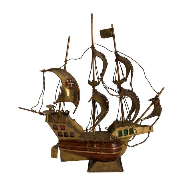 A spectacular decorative light fixture crafted from hammered brass and precious wood, inspired by the Portuguese caravels...