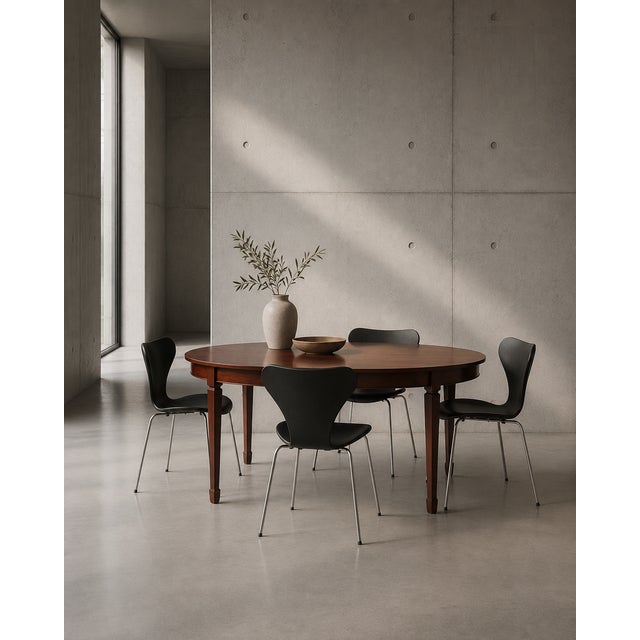 Mahogany dining table executed in the hepplewhite style with oval ends and lightly tapered legs. the table is crafted in...