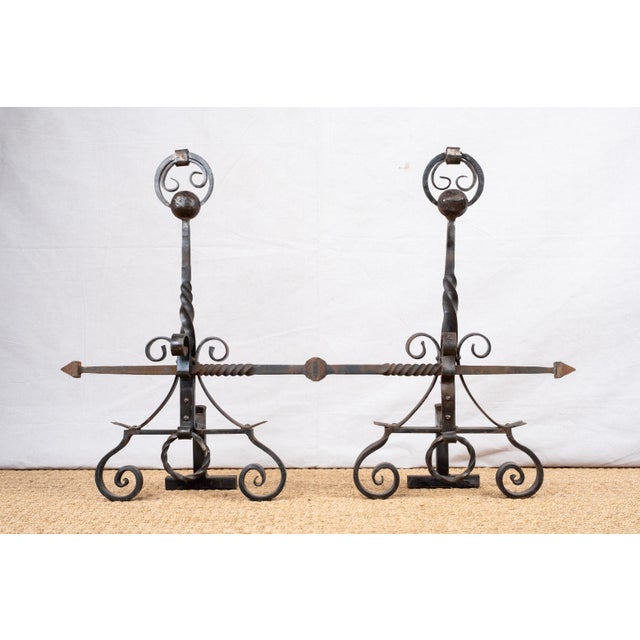 A set of wrought iron andirons, early 20th century, Italian. Featuring ball finials with operable rings (shown up in...