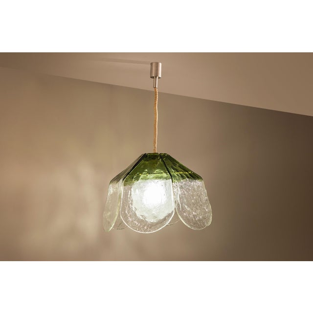 A flower translated into glass and light, carlo nason’s ls 182 hanging lamp brings an organic quality to murano glass....