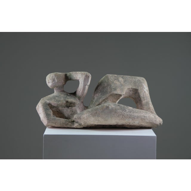 An elegant sculpture of a reclining female nude, crafted from reconstituted stone in the 1950s–1960s. This work fully...