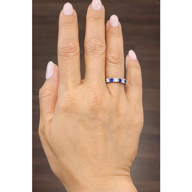 This elegant sapphire and diamond band ring is a striking expression of modern sophistication, beautifully crafted in...