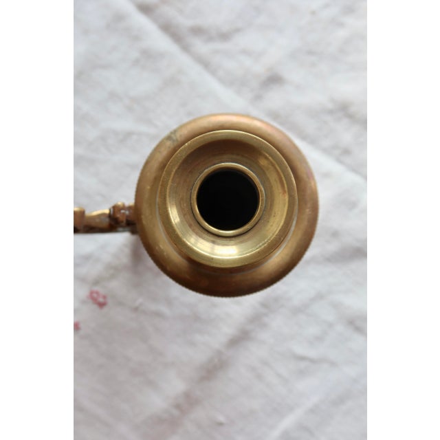 Pair of brass wall sconces with openwork decoration, adorned with a stylized griffin motif and elegant scrolls in an...