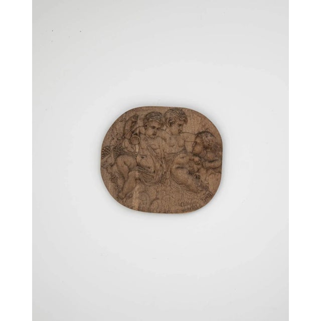 Intricate and intriguing, this vintage wooden wall decoration is carved to depict a scene of cherubs in a bacchanal. Made...