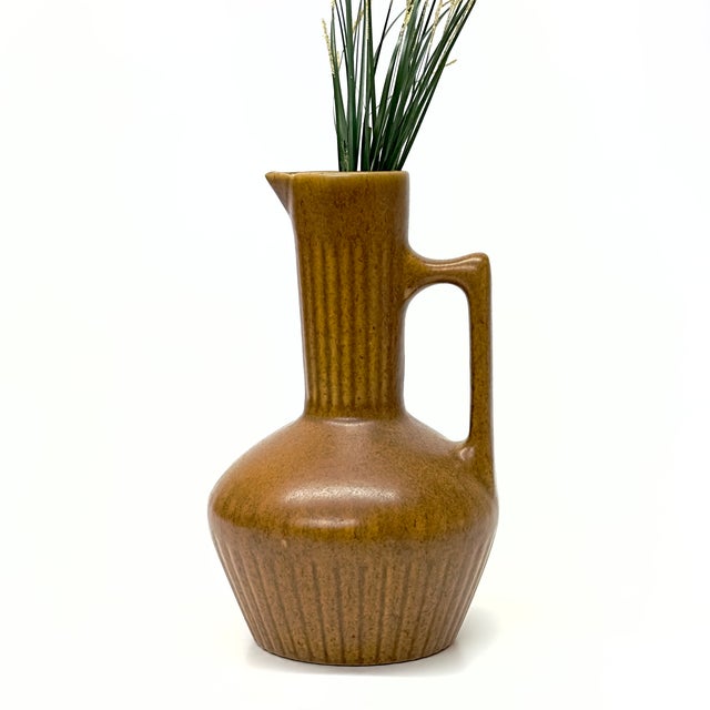 Neutral tan ceramic pitcher This is a mid-century modern semi-matte neutral-tan ceramic pitcher featuring a long neck...