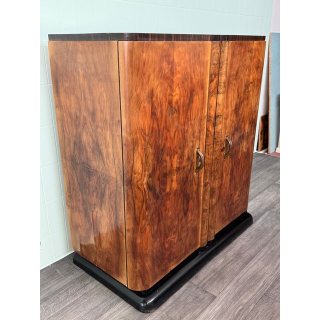 This refined Art Deco-style double-door wardrobe is crafted from walnut burl and dates back to the 1930s or 1940s in...