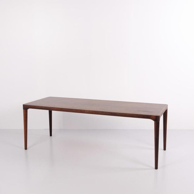 Rectangular rosewood coffee table from Danish furniture production in the 1960s. The table features a simple tabletop,...