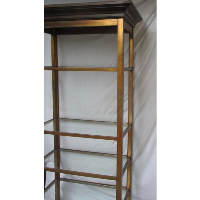 Vintage 70s gilt wood etagere with 5 shelves. Darkened and patinaed gold frame with stains, spots, and rubbed finish. The...