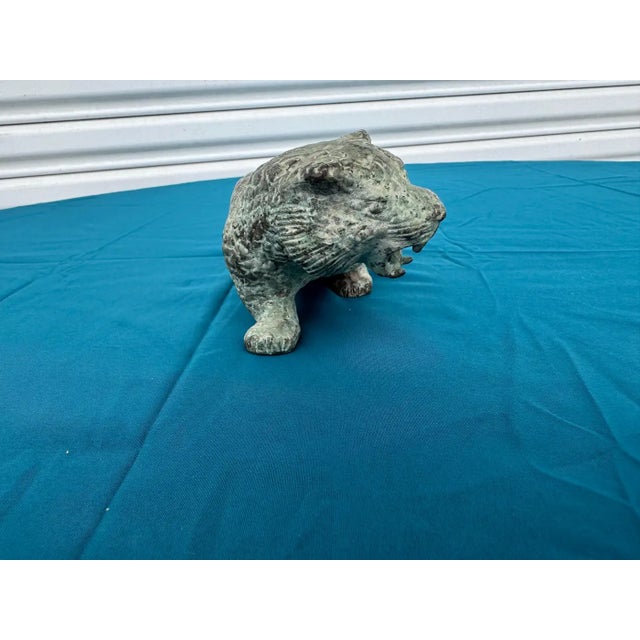 This is a bronze sculpture of a Leopard. The leopard shows its spots as it walks around territorial.