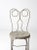 A vintage ice cream parlor chair crafted in painted Gainsboro light gray metal, featuring an ornate silhouette with...