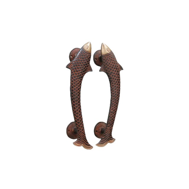 A pair of fish shaped door handles or cabinet pulls, made of brass and cast with line details to show eyes, scales and...